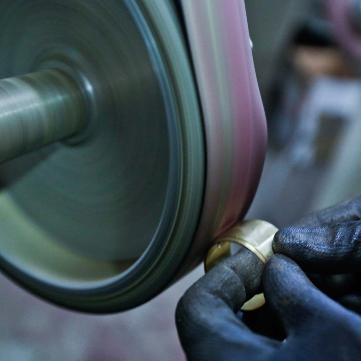Handwerker an der Bandschleifmaschine